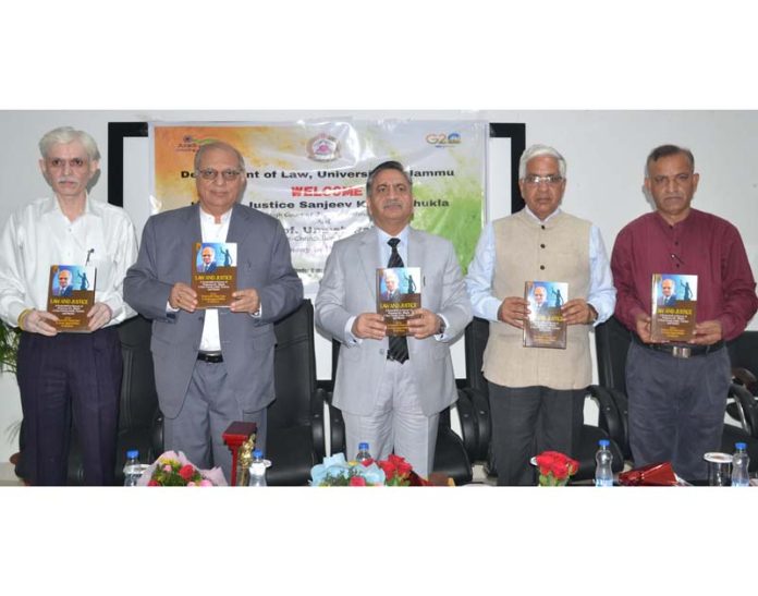 Justice Sanjeev Kumar Shukla along with JU VC Prof Umesh Rai and other dignitaries launching Prof KL Bhatia's book.