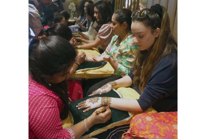 Artists from Jaipur adorning hands of ladies by making beautiful Mehndi designs at Fashion TV Salon, Channi Himmat in Jammu. -Excelsior/Rakesh