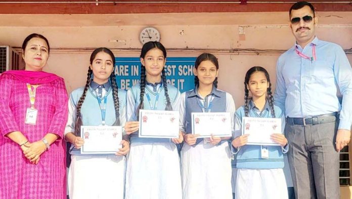 Students of Humanity Public School displaying certificates while posing with school management.