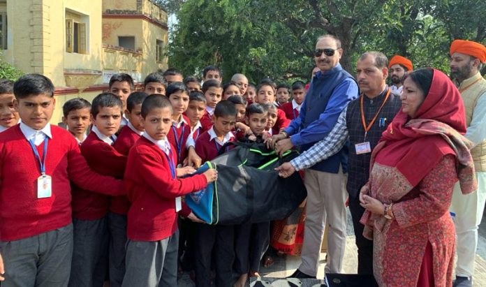 SSP Ashok Sharma (Retd), Secretary J&K Dharmarth Trust handing over sports kits to students.