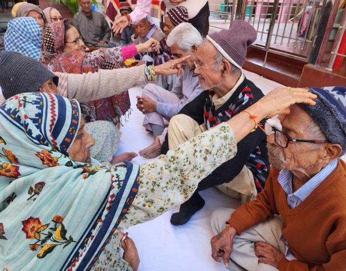 Women inmates applying Tilak on forehead of male inmates at Old Age Home, Ambphalla Jammu. -Excelsior/Rakesh