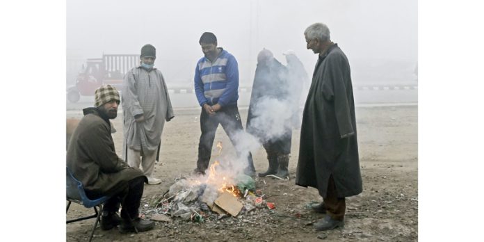 People warm themselves amid chilly weather conditions in Srinagar on Tuesday. — Excelsior/Shakeel