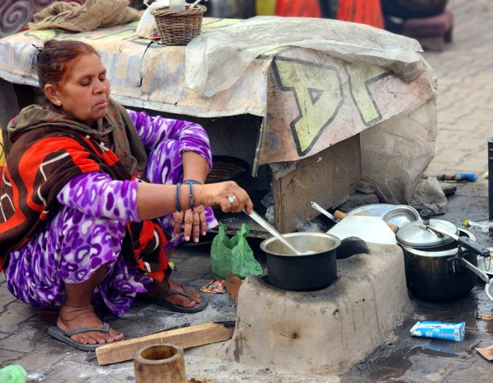 A woman prepares food on traditional earthen stove on the outskirts of Jammu. —Excelsior/Rakesh