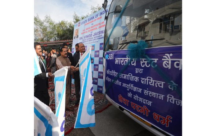 Union Minister Dr Jitendra Singh along with CGM SBI Vinod Jaiswal handing over keys of bus to Director AIIMS Vijaypur Dr Shakti Gupta at Jammu on Friday. —Excelsior/Rakesh