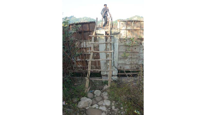 A villager climbing on the Ujh bridge through wooden ladder/staircase near Jathana village n Kathua.-Excelsior/Pardeep
