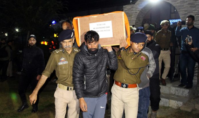 Police officers and others carry the coffin of martyr cop for wreath laying ceremony at DPL Baramulla on Tuesday. -Excelsior/Aabid Nabi