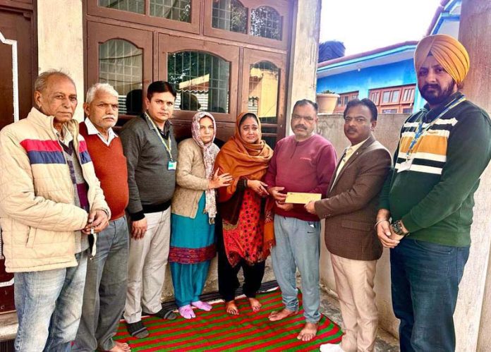 LIC officials handing over cheque to wife of martyr Joginder Singh at Village Abtal Katalan in Samba district on Thursday.