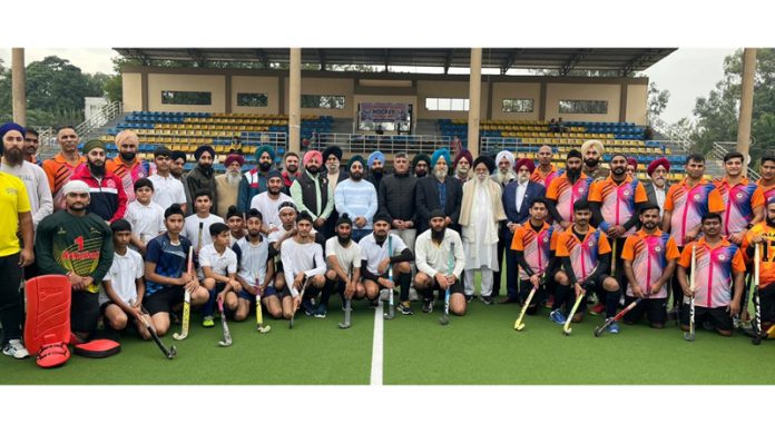 Hockey teams posing with dignitaries at K K Hakku Hockey Stadium Jammu.