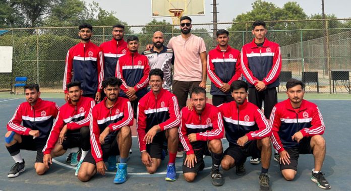 JU Basketball (M) Team posing with their coach and manager.