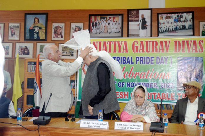 Chairman of Gurjar Desh Charitable Trust puts traditional turban on head on the chief guest during `Janjatiya Gourav Diwas' celebration programme on Wednesday.