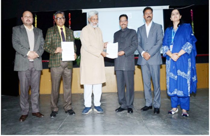 Th Gulchain Singh Charak and Dr Rajendra Singh display copy of MoU signed between Dogra Group of Colleges and Tarun Bharat Sangh.