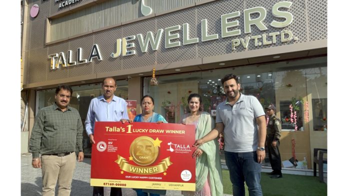 Officials of Talla Jewellers presenting 25 Gram Gold Coin to the 1st lucky draw winner of IJSF in front of their showroom in Jammu.