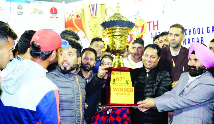 Players of J&K Football team and YSS officers posing with winner’s trophy.