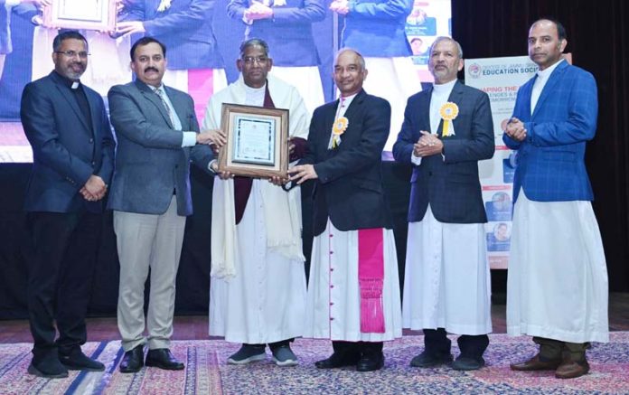 Fr Varkey TJ being honoured with Lifetime Achievement Award during a programme by DJSES.