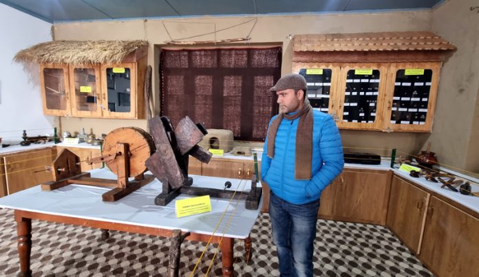 Professor Zahoor Ahmad examines historical items at the newly established museum in Government Boys Higher Secondary School Baramulla in North Kashmir. -Excelsior/Aabid Nabi