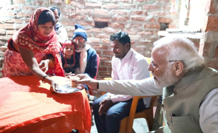 PM Narendra Modi taking tea at the residence of a Dalit woman in Ayodhya.
