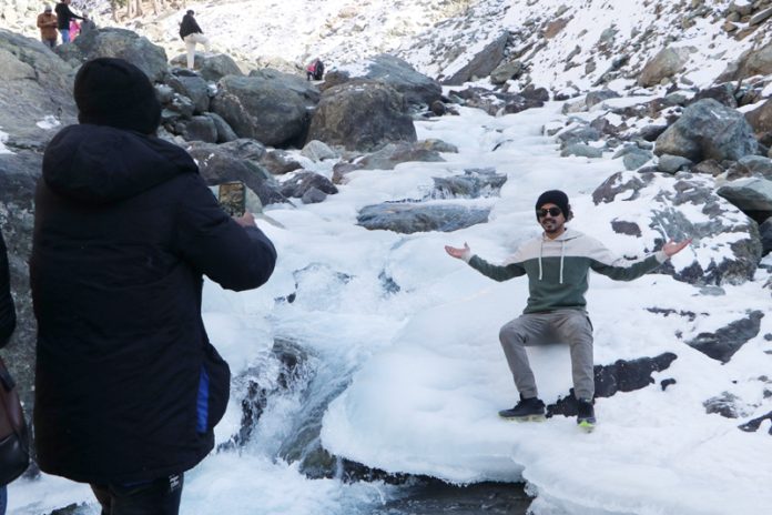 As Kashmir temperature continues to dip, tourists enjoy at freezed river Lidder at Chandanwari Pahalgam, in Anantnag district on Friday. (UNI)