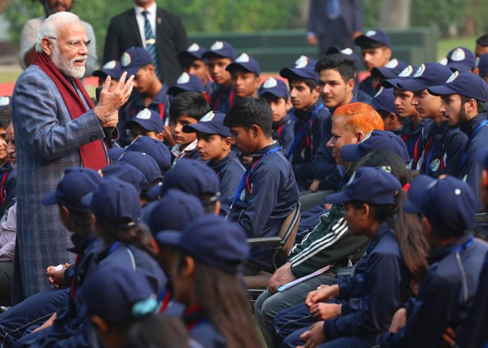 Prime Minsiter Narendra Modi interacting with students of Jammu and Kashmir at his residence in New Delhi on Sunday. (UNI)