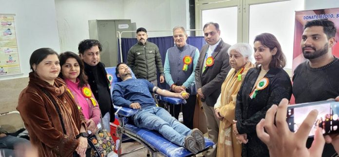 A volunteer donates blood during a camp at Jammu on Saturday.