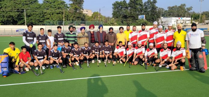 Guests and match officials posing with a team at KK Hakku Hockey Stadium, Jammu on Friday.