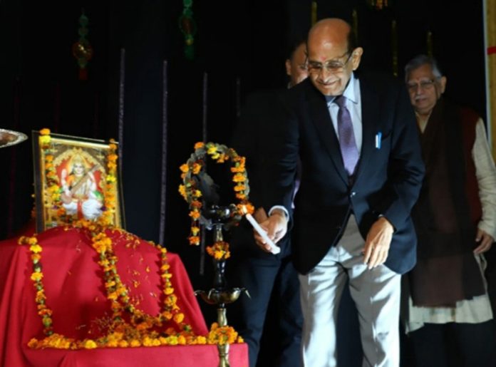 A dignitary lighting ceremonial lamp during a conference at GLDM GDC Hiranagar.