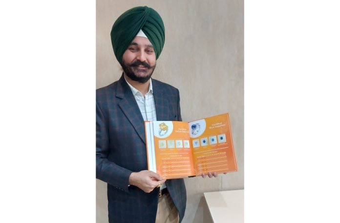 Surinder Singh, Senior Manager Sales at Gem Labs, Amritsar displays a brochure with details of gems.