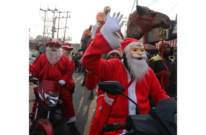 Christian youth wearing Santa Claus masks during Christmas procession in Jammu city on Friday. -Excelsior/Rakesh