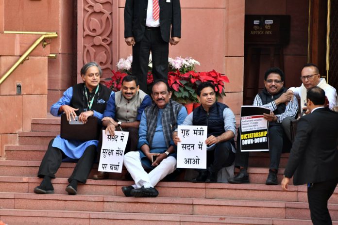 Suspended MPs and others sitting on the stairs of Makar Dwar at Parliament House, in New Delhi on Monday. (UNI)