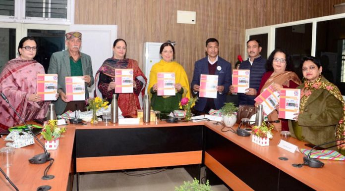 Dignitaries displaying college magazine during a programme.