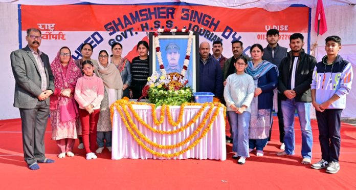 Students and others pose for a group photograph after paying tributes to Martyr Shamsher Singh in Jourian area of Akhnoor.