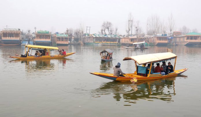 Tourists enjoying Shikara ride on Dal Lake as foggy conditions improve in Srinagar on Saturday. -Excelsior/ Shakeel