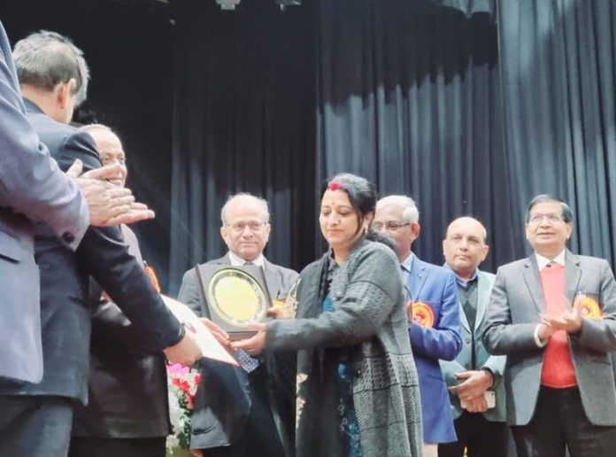 Dr Poonam Parihar being presented with award.