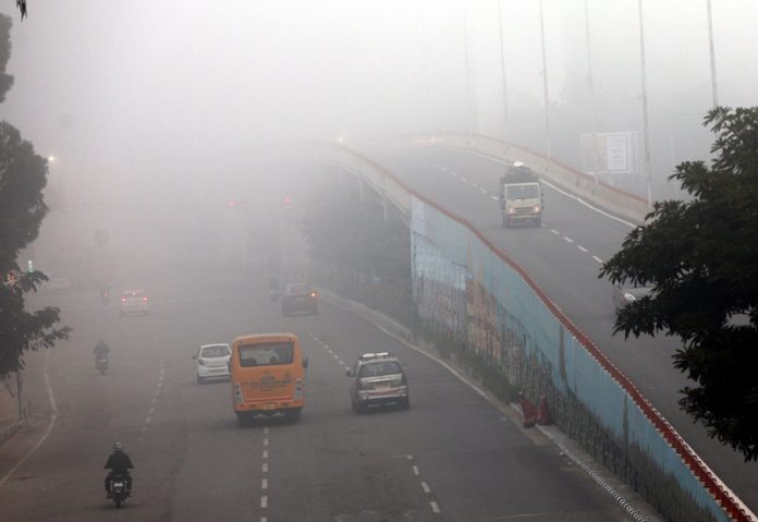 Vehicles plying amid dense fog in Jammu on Wednesday morning. -Excelsior/Rakesh