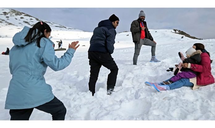 Tourists enjoying with snow at Sinthan Top on Anantnag Kishtwar border. -Excelsior/Sajad Dar