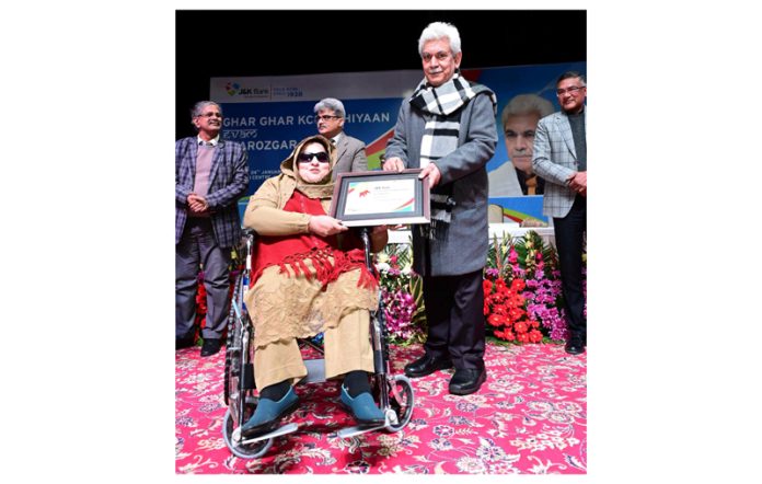 LG Manoj Sinha hands over letter to a beneficiary in Jammu on Wednesday.