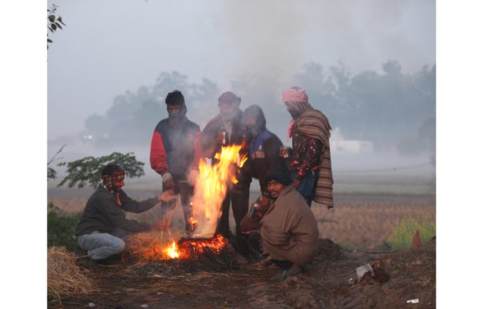 Amidst chilling cold and fog, people lit fire for warming themselves in Jammu's outskirts on Tuesday. -Excelsior/Rakesh