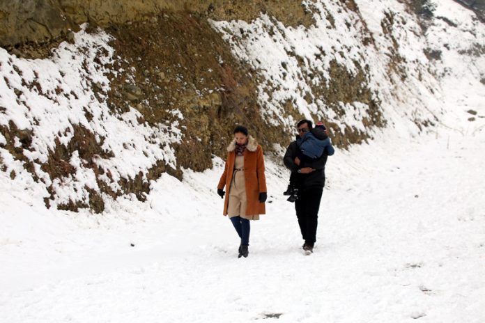 Tourists enjoying snowfall on Mughal Road in Shopian. -Excelsior/Younis