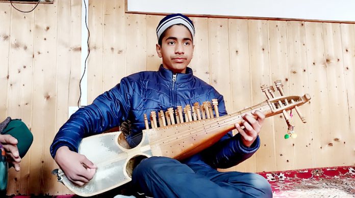 Ishfaq engrossed in playing Rabab at his residence at Kreeri in North Kashmir's Baramulla district. -Excelsior/Aabid Nabi