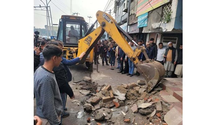 An illegal pavement being dismantled in Gujjar Nagar area of the city on Wednesday. -Excelsior/Rakesh