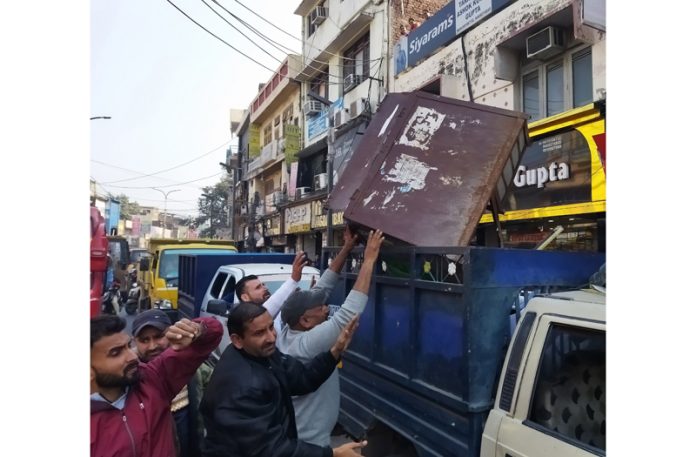 Anti-encroachment team loading seized items in JMC vehicle.