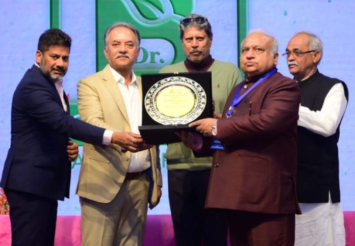 Dr Shaktidhar Sharma receiving award from cricketing legends, Kapil Dev and Madan Lal Sharma, at Lucknow.