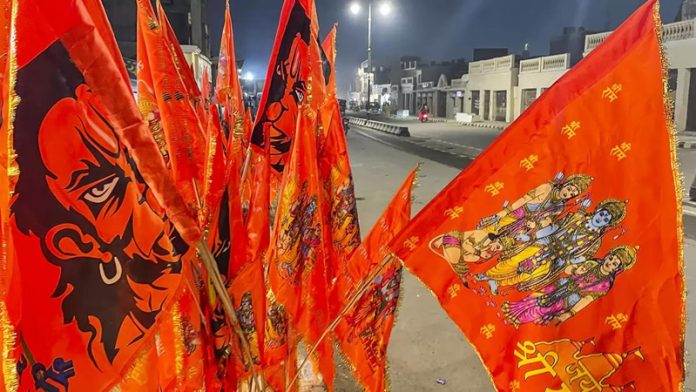 Saffron flags bearing images of Lord Ram, Lord Hanuman and the upcoming grand temple on display in front of shops along Ram Path, in Ayodhya. Ahead of the Ram temple consecration ceremony in the holy city, demand for such flags has risen manifold.