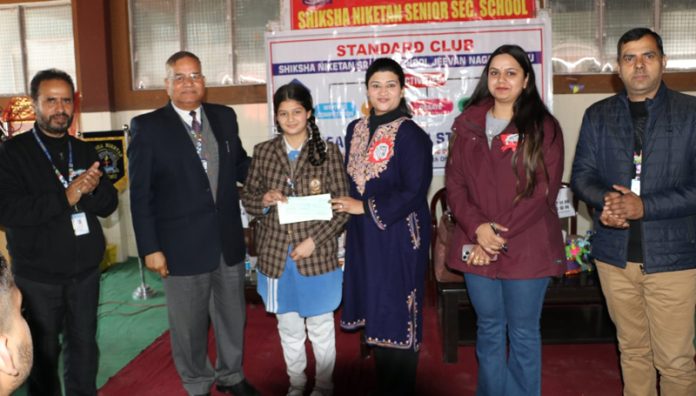 Dignitaries presenting cash award to students during writing competition at Jammu. 