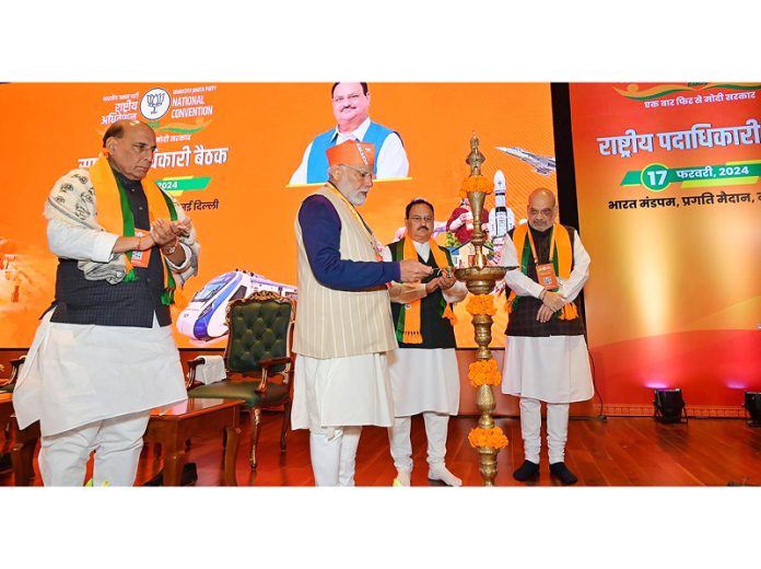 Prime Minister Narendra Modi lights lamp as BJP president J P Nadda, Defence Minister Rajnath Singh and Union Home Minister Amit Shah look on at the BJP National Council meeting at Bharat Mandapam, in New Delhi on Saturday.(UNI)