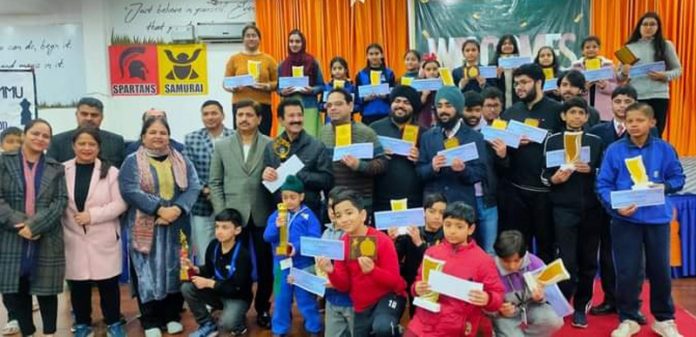 Chess players posing for group photograph while displaying certificates and prizes at IDPS Jammu on Sunday.