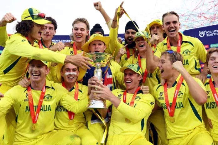 Australian Under-19 cricket team posing with World Cup trophy.