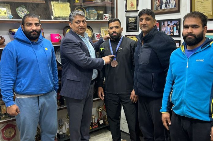 Former International Wrestler and SSP, J&K Police Dushyant Sharma felicitating wrestler Munir Ahmad for winning Bronze medal at National Championship.