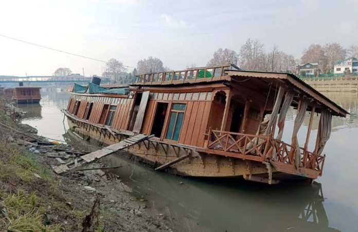Damaged houseboat in river Jhelum at Rajbagh on Tuesday. -Excelsior/Shakeel