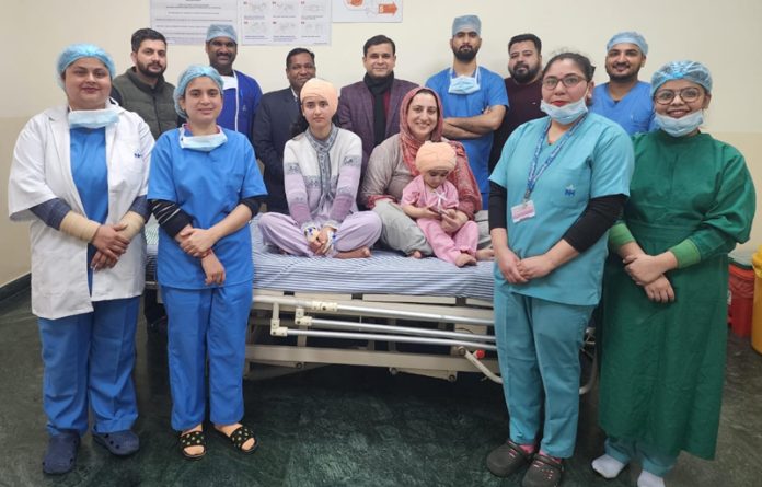 A team of SMVDNSH doctors posing with two children on whom cochlear implant surgeries were performed by them.