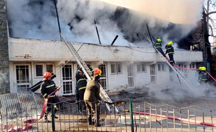 Fire Services men fighting fire at MLA hostel in Srinagar on Friday. -Excelsior/Shakeel.